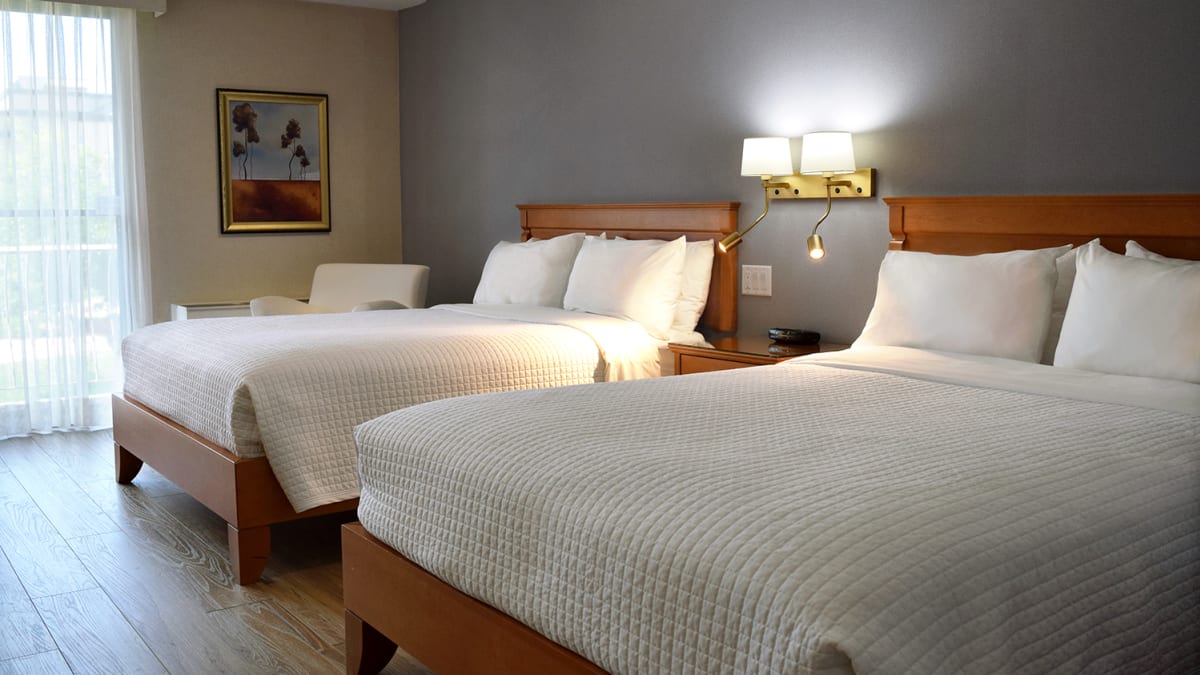 Room with two large beds at Hôtel Castel.