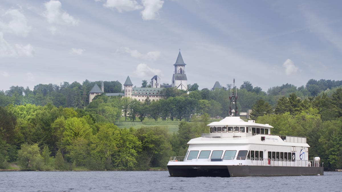 Cruise ship on a lake. There is an abbey in the background.