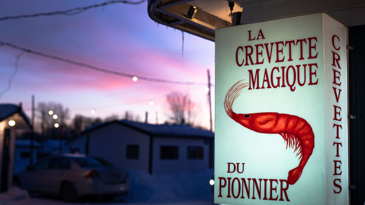 Outfitter sign and ice fishing village in the early evening.