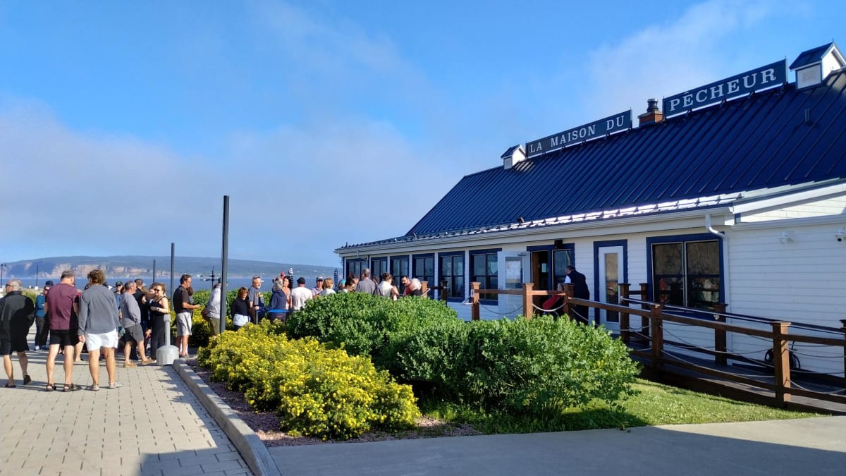 People lining up outside a restaurant called La Maison du Pêcheur.