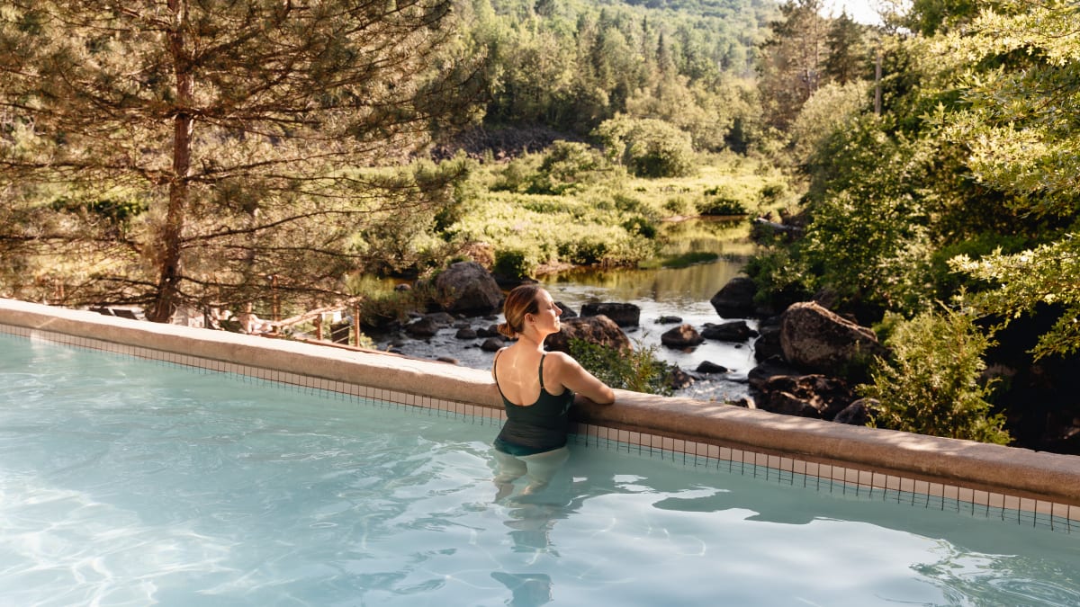 Femme en train de contempler la nature dans une piscine.