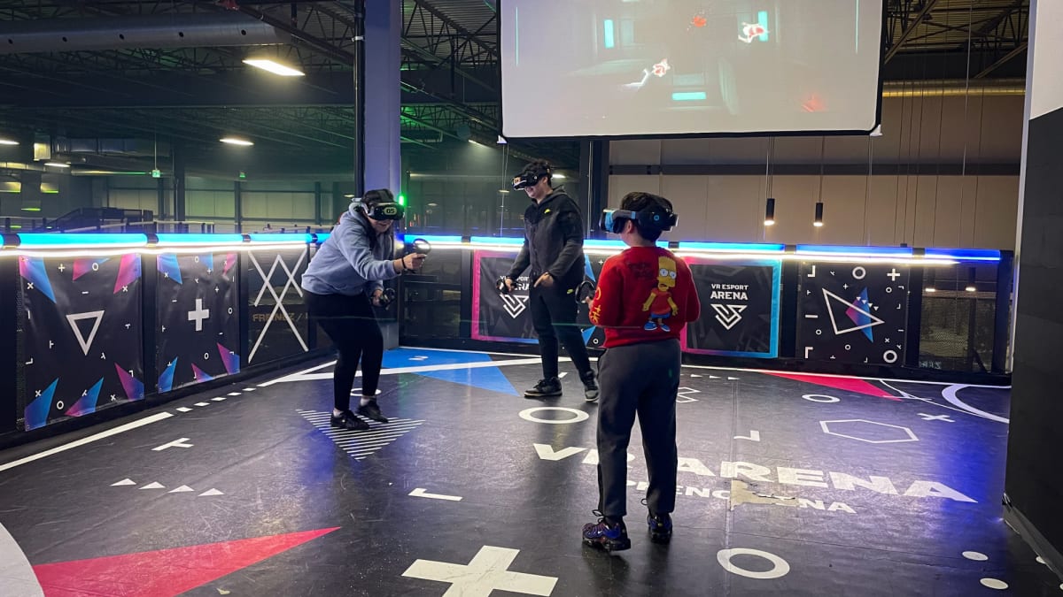 Three people facing off in a virtual reality arena.