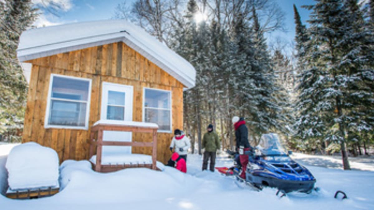 Chalet in winter with snowmobiler