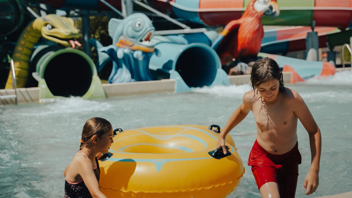 Young girl and boy with an inflatable tube in a pool.