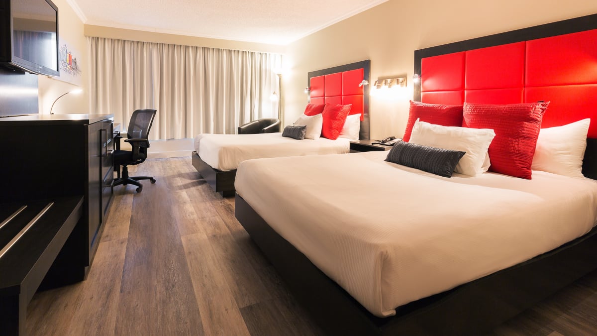 Intérieur d’une chambre d’hôtel aux accents rouges avec deux grands lits