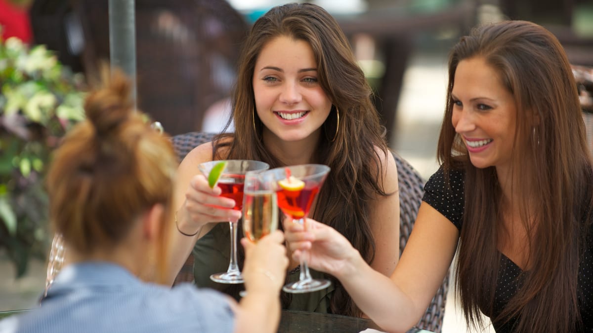 Three women raising their glass in a toast.