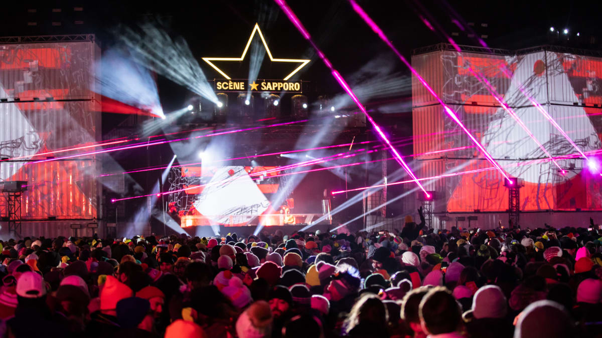 Festival crowd under the evening lights.