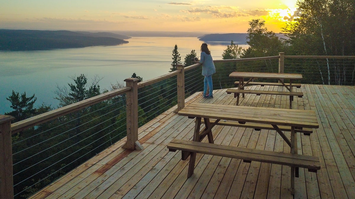 Woman on a patio looking at the Saguenay River.