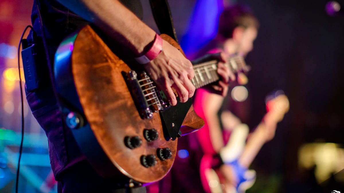 Musician playing guitar at a live show.