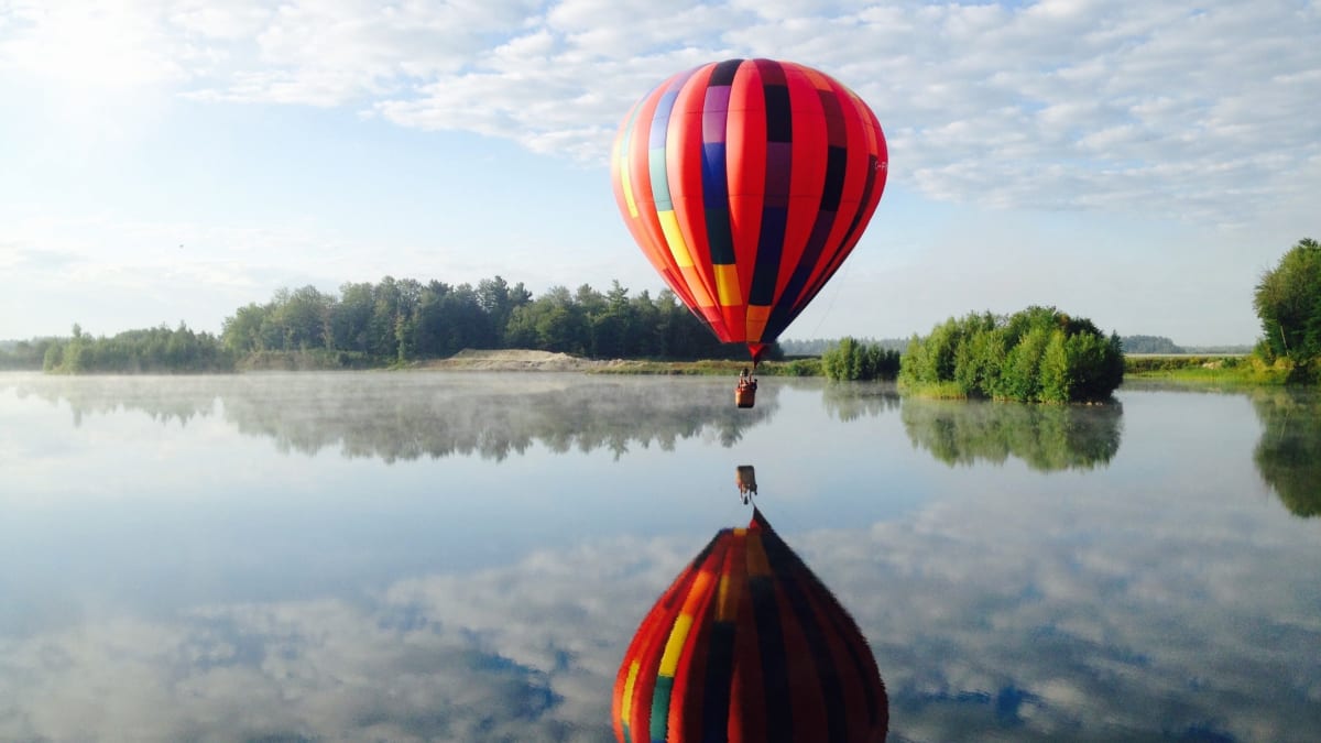 Montgolfière au-dessus d'un lac.
