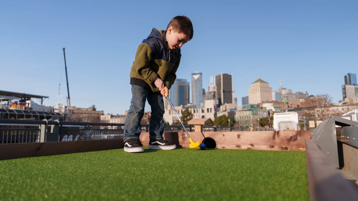 Young boy playing mini-putt