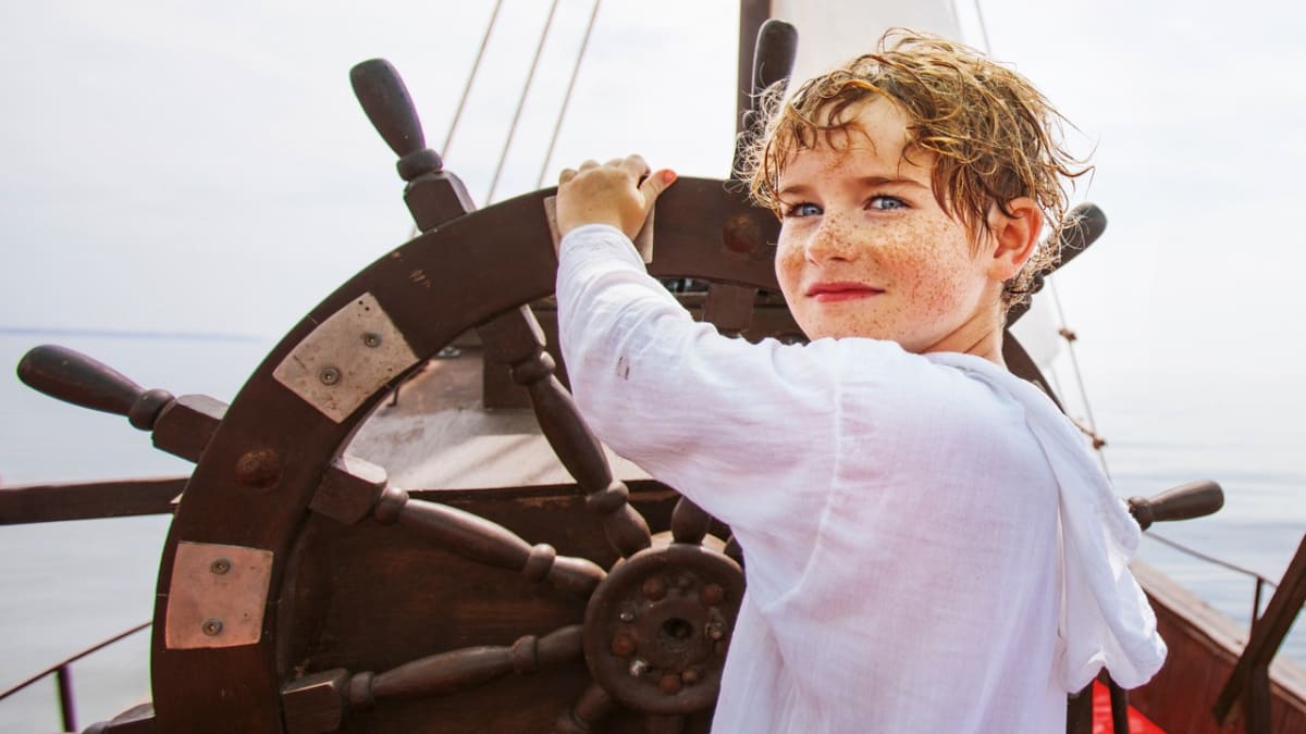 Young boy at the helm of a ship