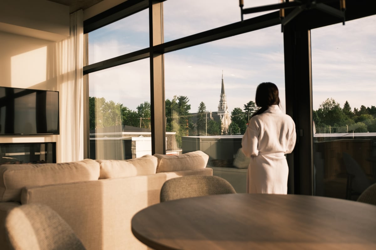 Woman wearing a bathrobe inside a condo-style lodging.