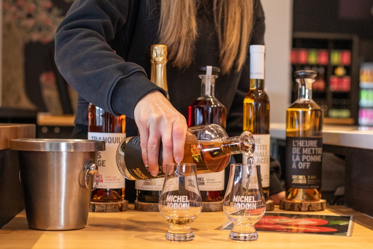 Femme qui prépare une dégustation de cidres.