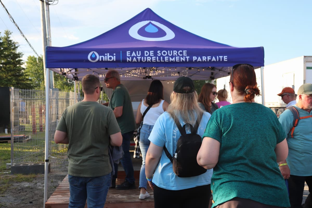 Festivalier·ères en ligne pour avoir de l'eau au H2O Festival.