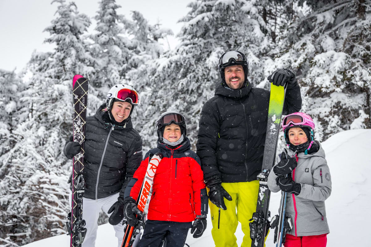 Family on skis on a ski hill.