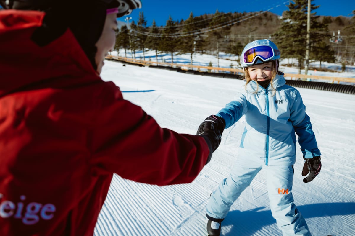 Girl on skis and an instructor.