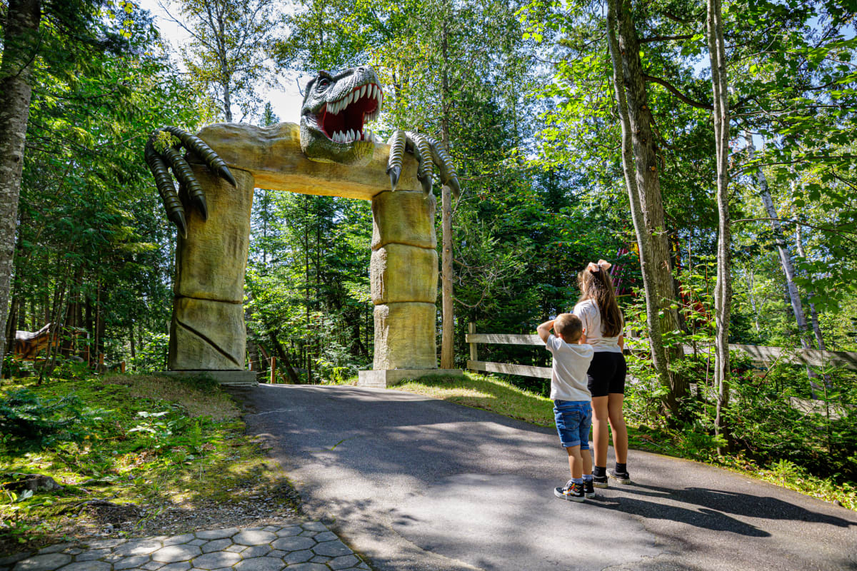 Two children in front of a door topped with a dinosaur head