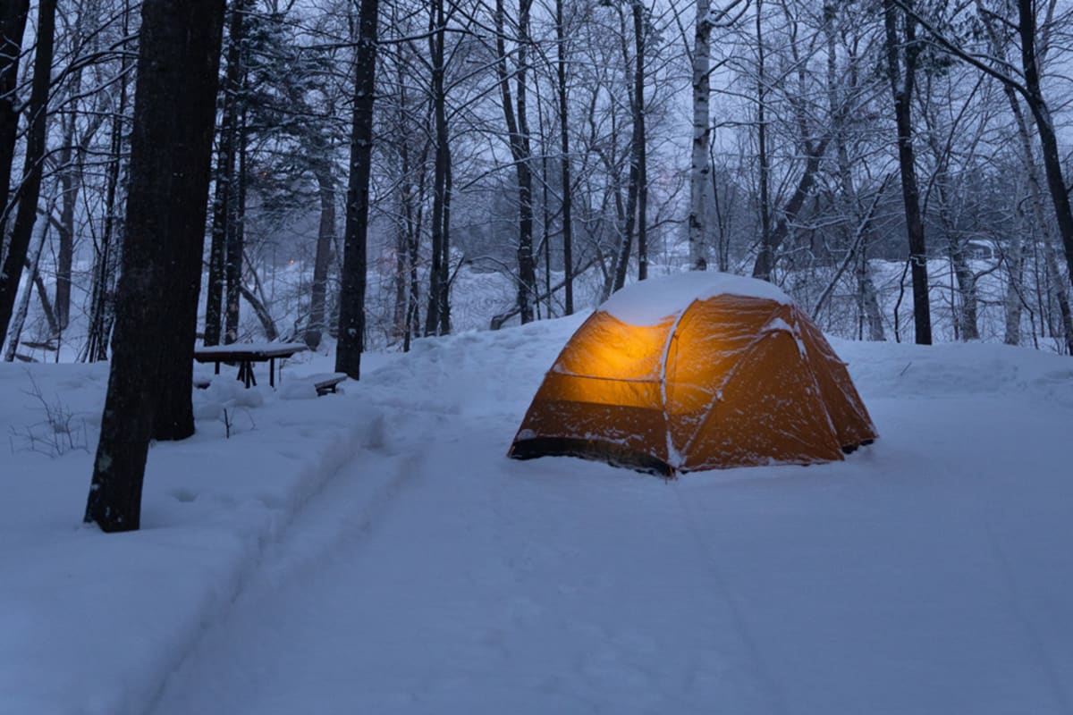 Lighted camping tent on snow