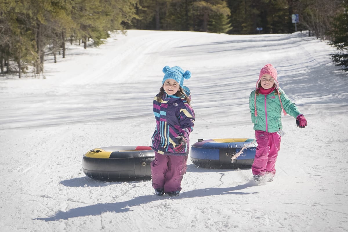 Two girls snow tubing in Charlevoix.