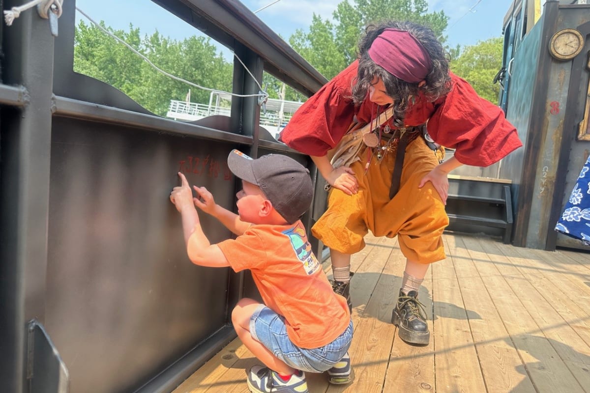 Kid and costumed presenter on a pirate ship.