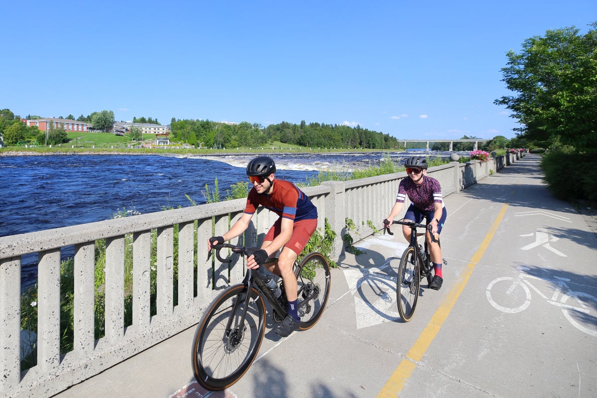 Two cyclists on a waterfront bike path.