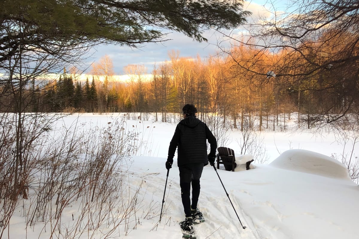 A man on snowshoes in a snowy landscape.
