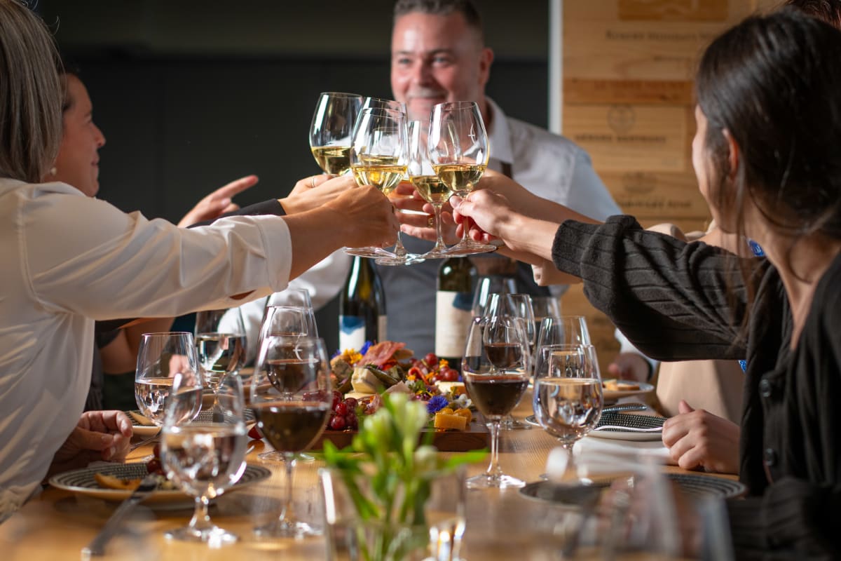 A toast with friends over glasses of white wine.