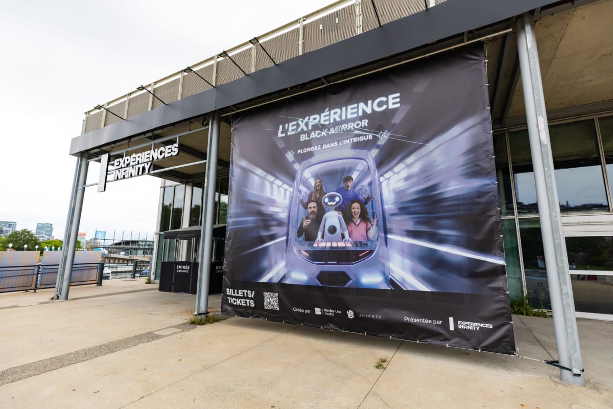 Extérieur du bâtiment d'Expériences Infinity accueillant l'Expérience Black Mirror, avec une grande affiche à l'extérieur.