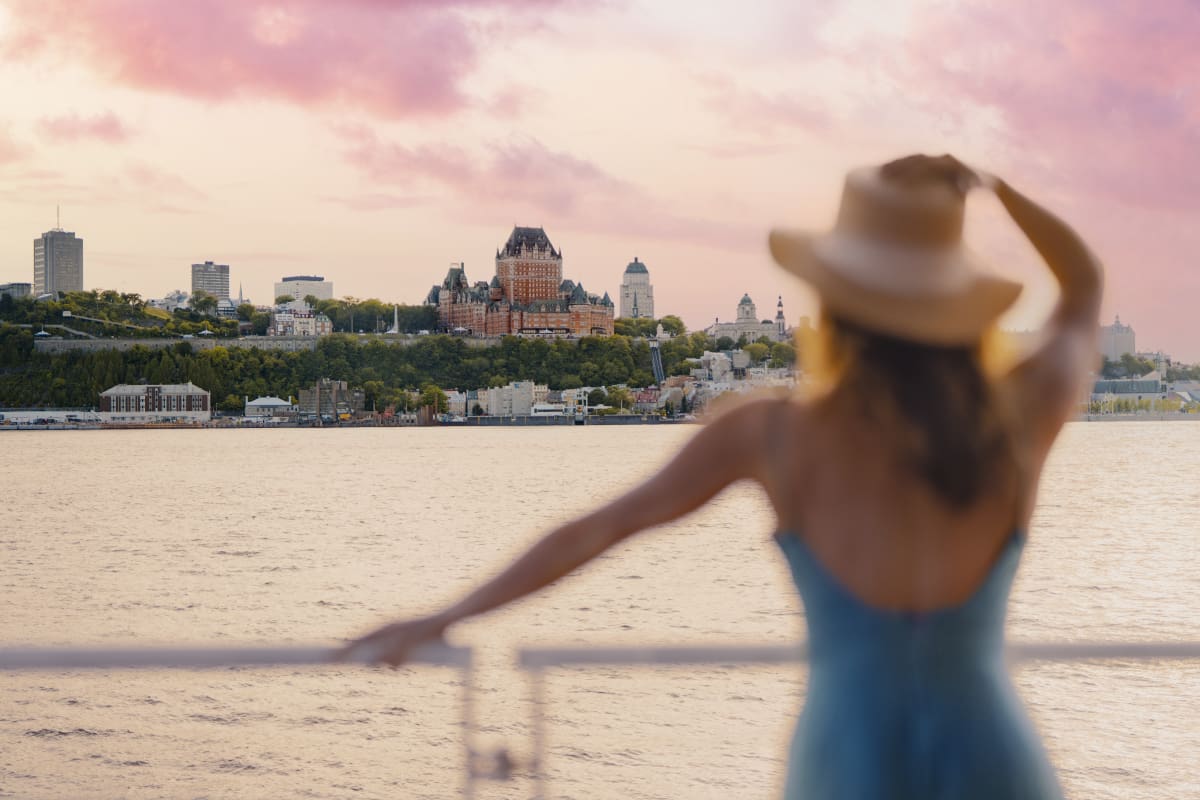 Femme qui regarde le Château Frontenac à partir du fleuve.