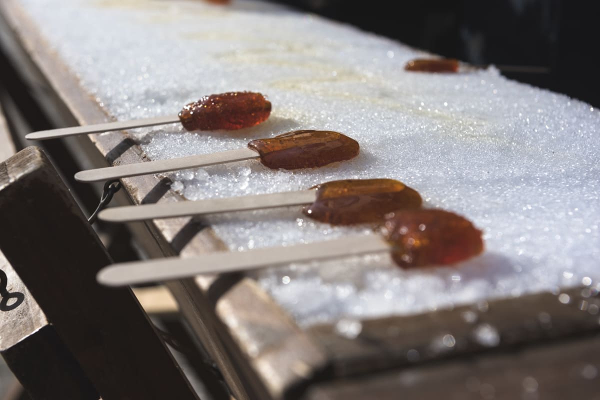 four sticks of maple taffy on snow.