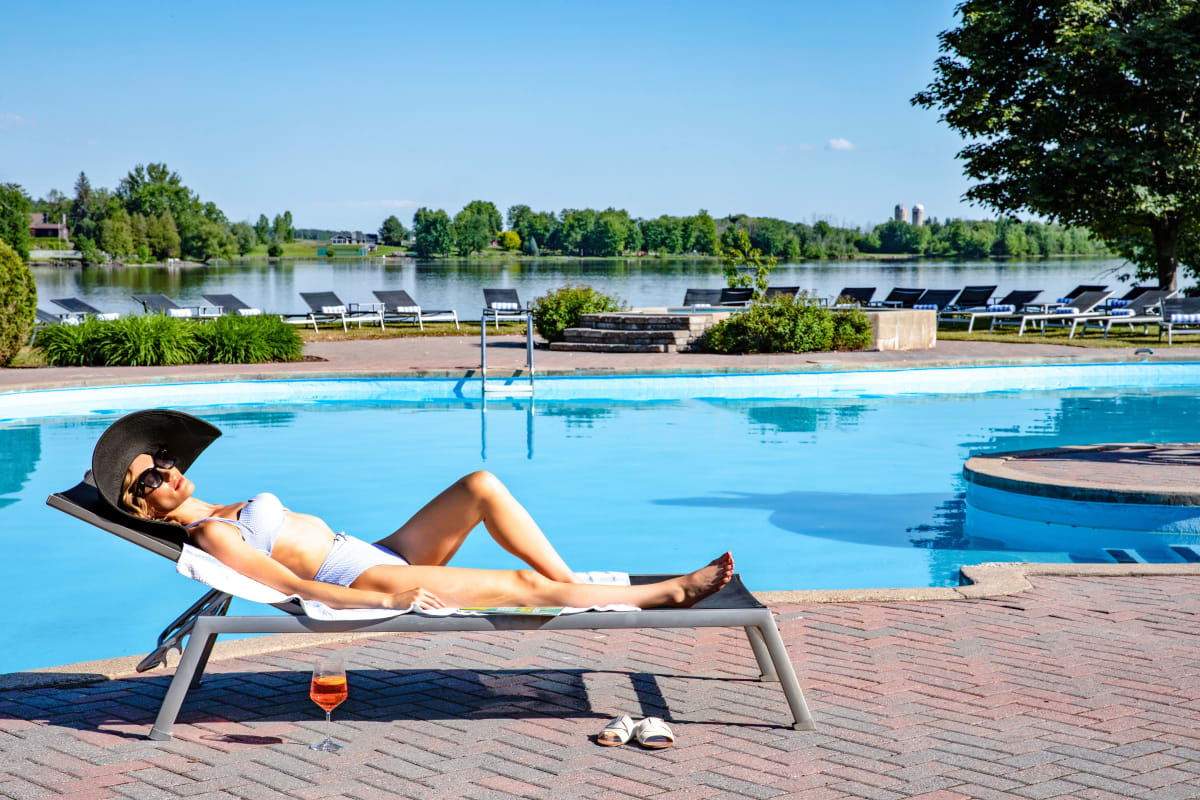 Femme au bord de la piscine du Château Montebello.