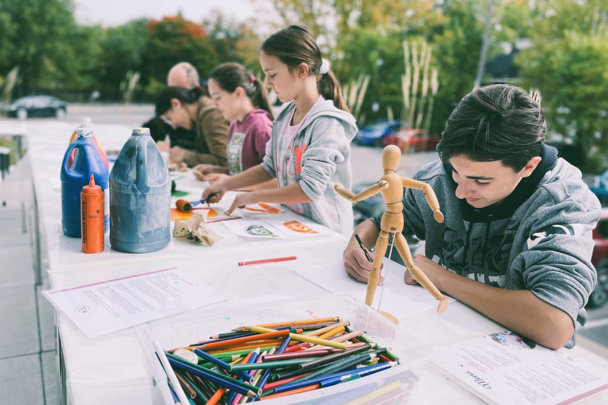 Enfants faisant des dessins à l'extérieur.