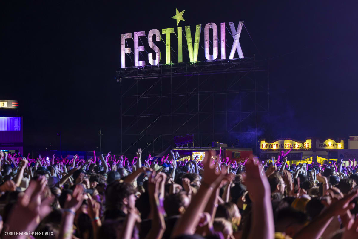 A crowd with their arms raised at the FestiVoix festival in Trois-Rivières.