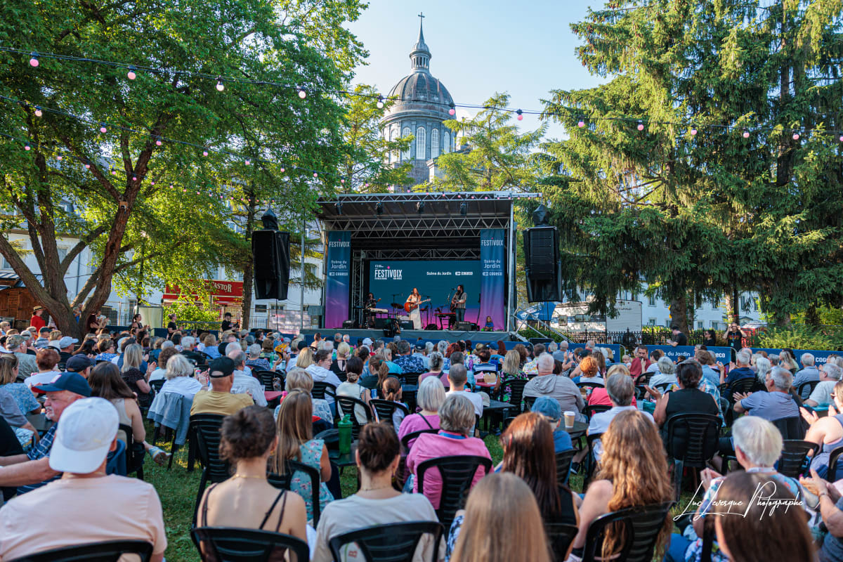 A seated crowd watches a small stage at the FestiVoix festival in Trois-Rivières.