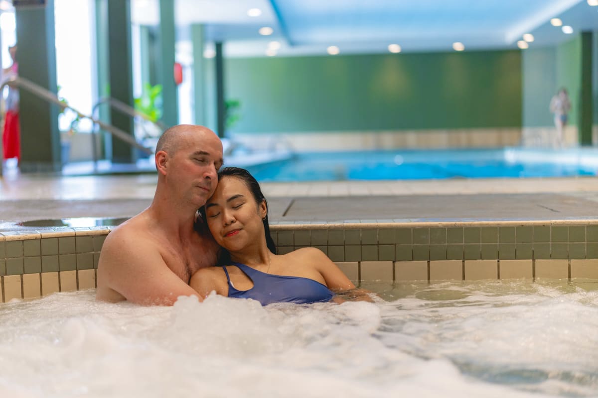 A couple entwined in a hot tub.