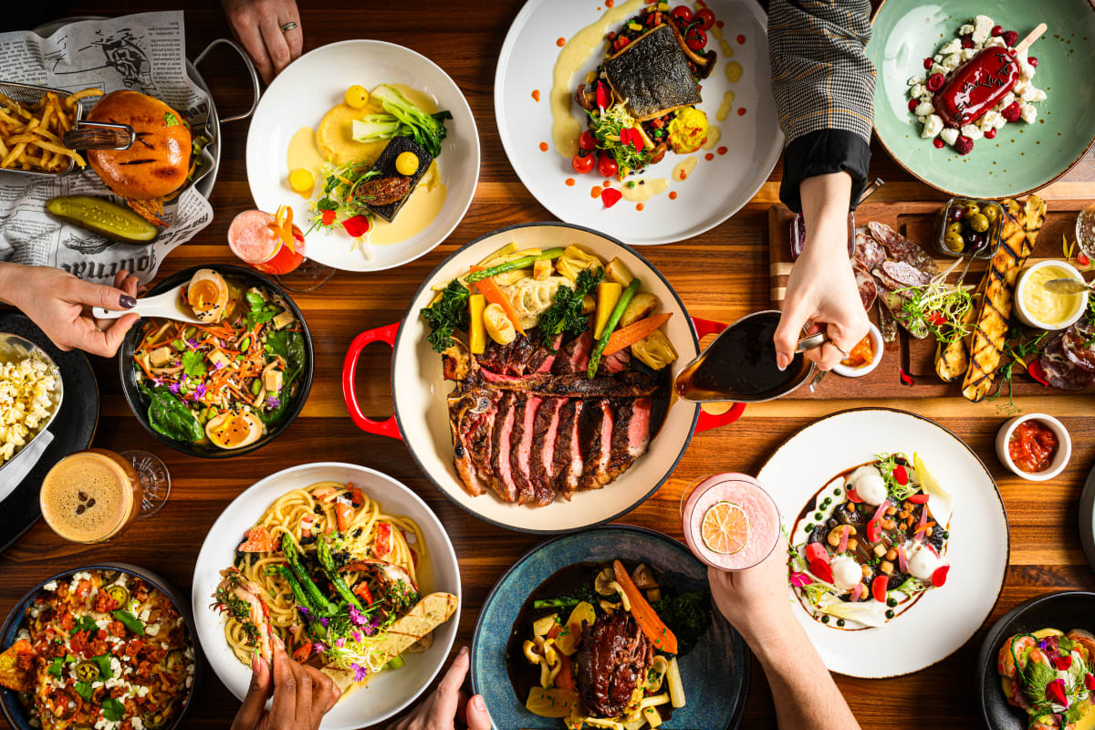 Large table filled with a variety of colorful, gourmet dishes, seen from above.