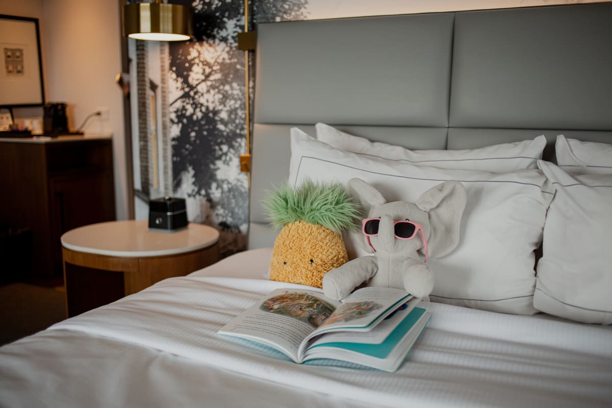 Stuffed animals on a hotel bed at the Hilton Québec, alongside a children’s book.