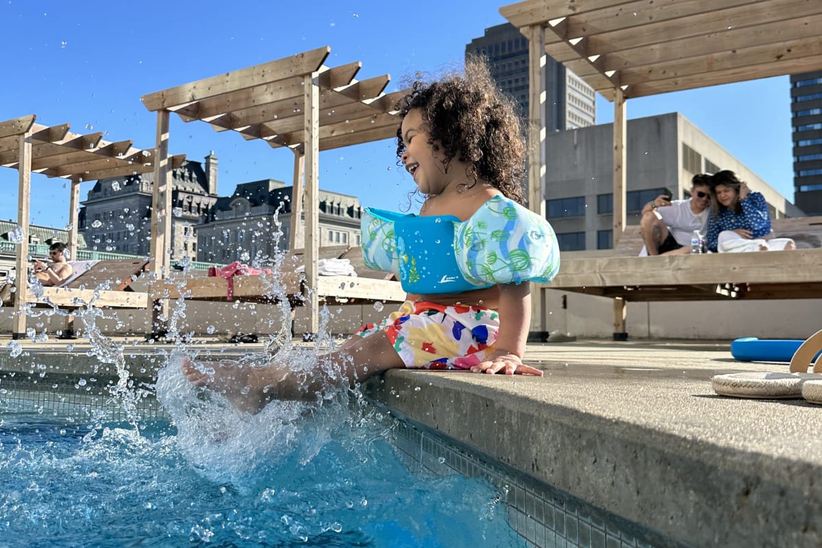 Little girl by the rooftop outdoor pool at Hilton Québec.