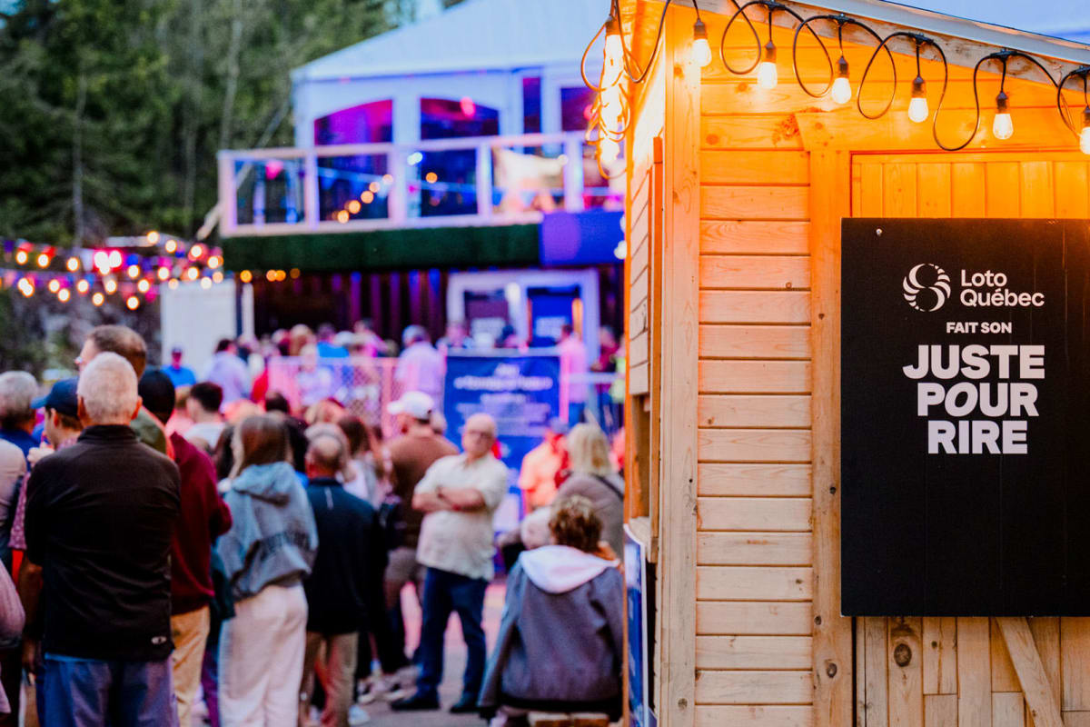 A crowd gathers outside in the evening at the Loto-Québec “Just for Laughs” event.