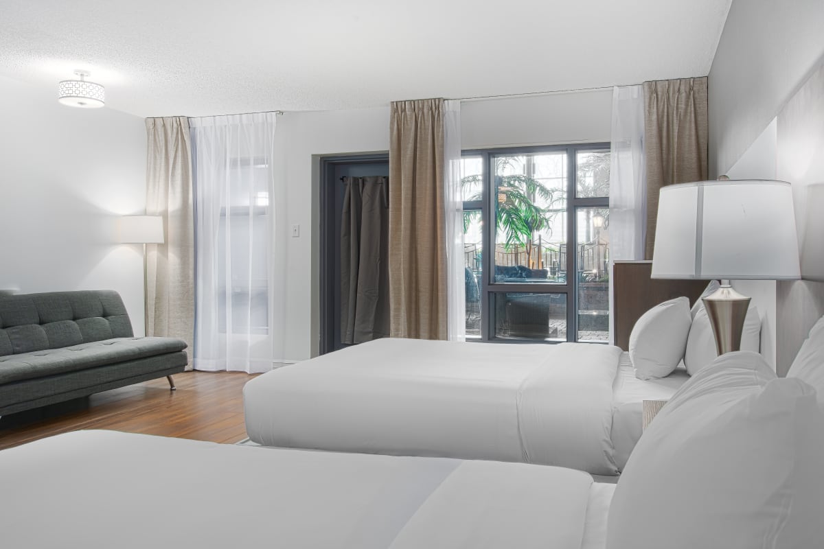Hôtel Universel Québec - Chambre blanche avec deux lits.