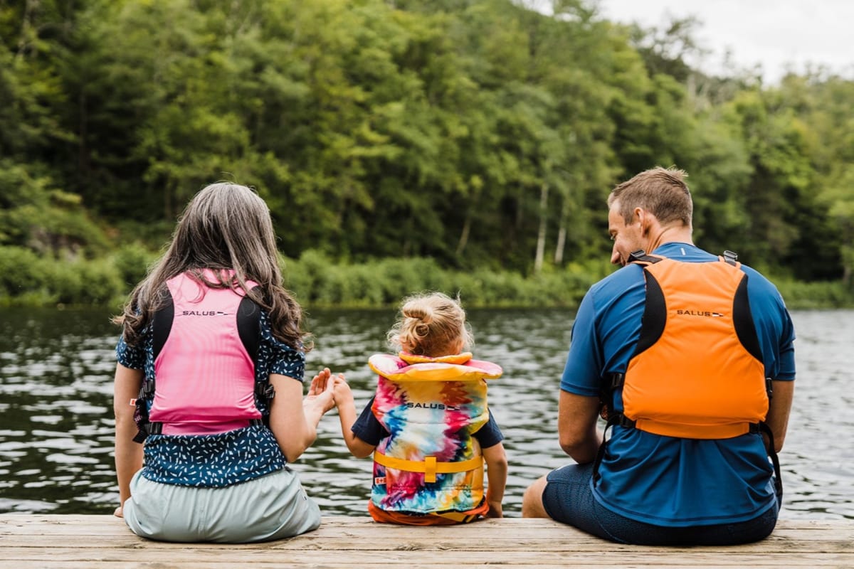 Kenauk Nature -  Two adults and a child on the edge of a quay, wearing life jackets
