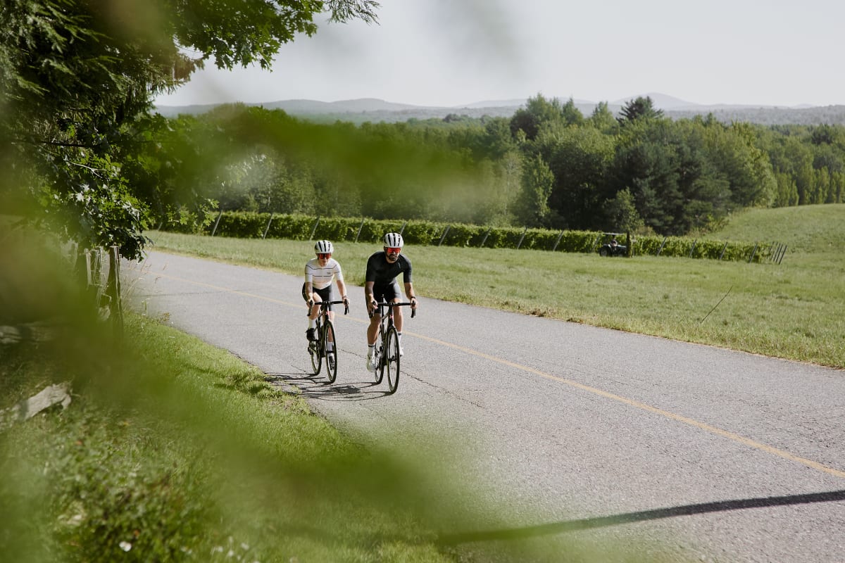 Two people on bicycles on a paved road.