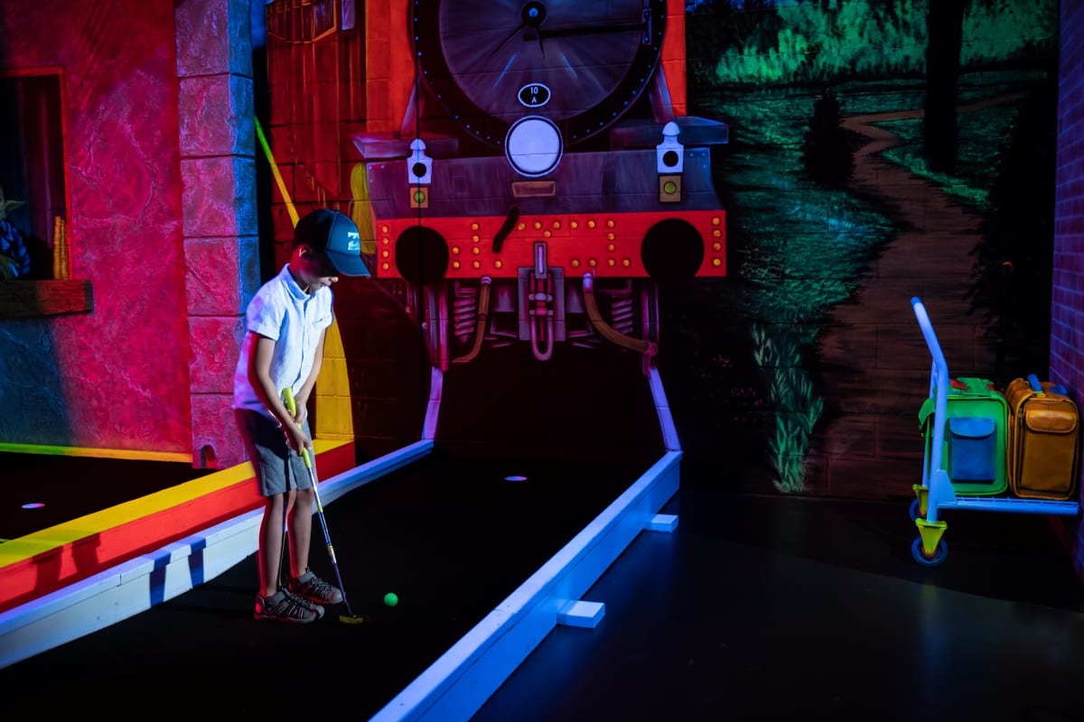 Children are playing a game of mini-golf at Laser Force Drummondville