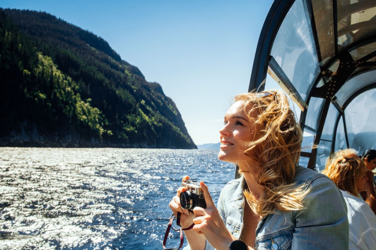 Les navettes maritimes du Fjord - A woman on a boat holding a camera.