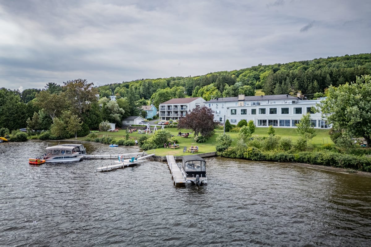 Lac Etchemin et le manoir installé sur ses rives, avec trois quais et des embarcations.
