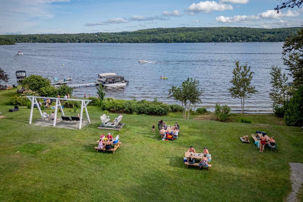 Groupes de personnes assises au bord de l'eau au Manoir Lac-Etchemin.
