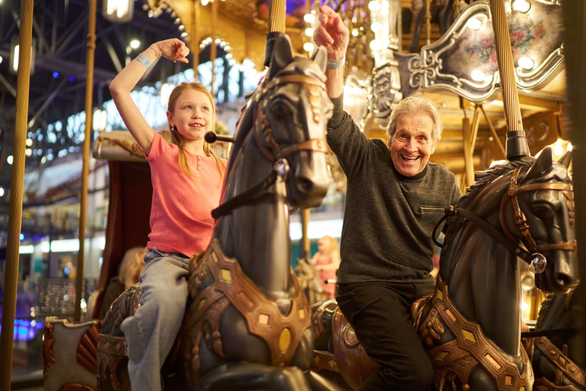 Fillette et homme dans un carrousel.