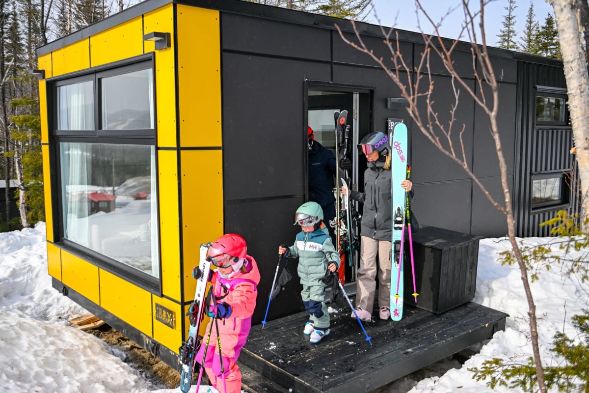 Family outside a Coolbox accommodation at Mont Grand-Fonds.