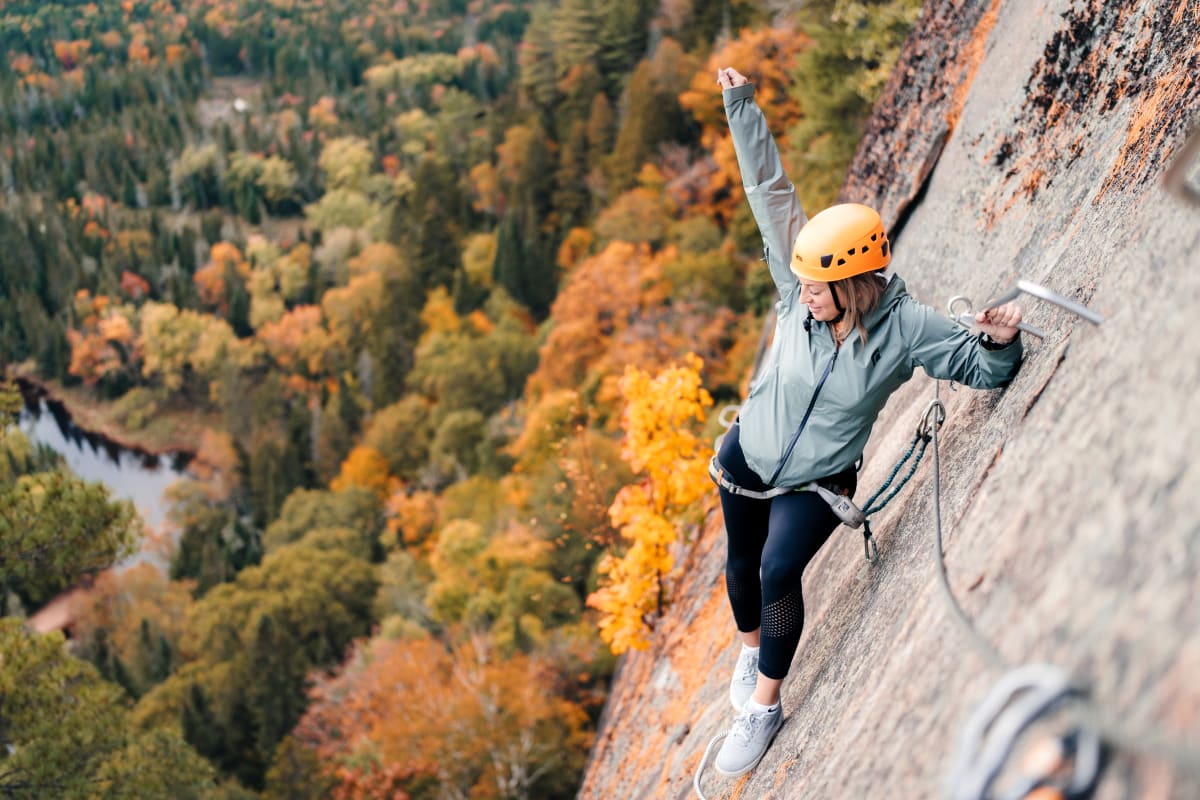 Woman on the via ferrata trail in the fall at parc national du Mont-Tremblant.